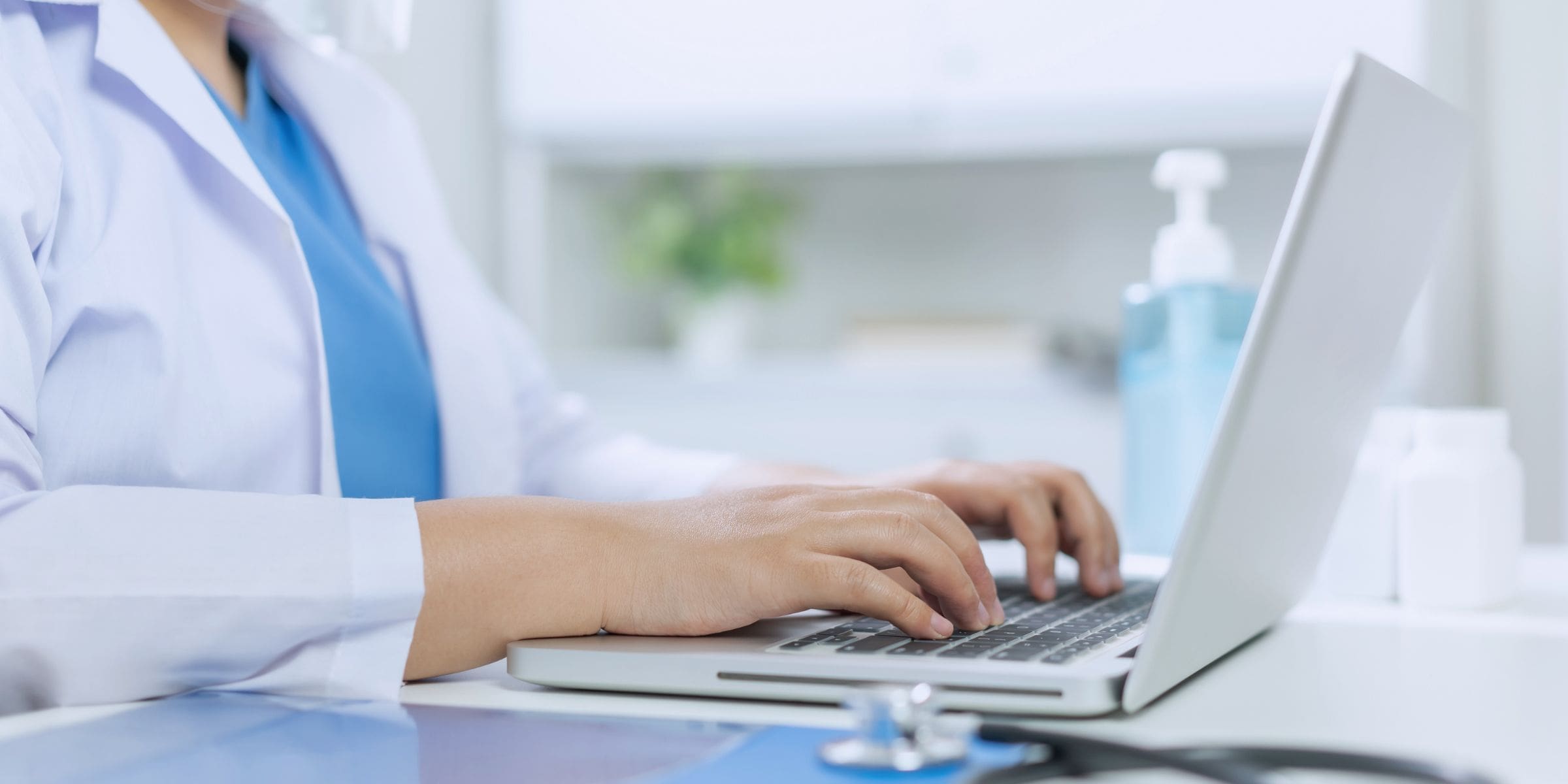 Hands typing on laptop