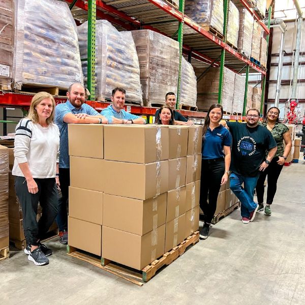Group of employees standing next to boxes