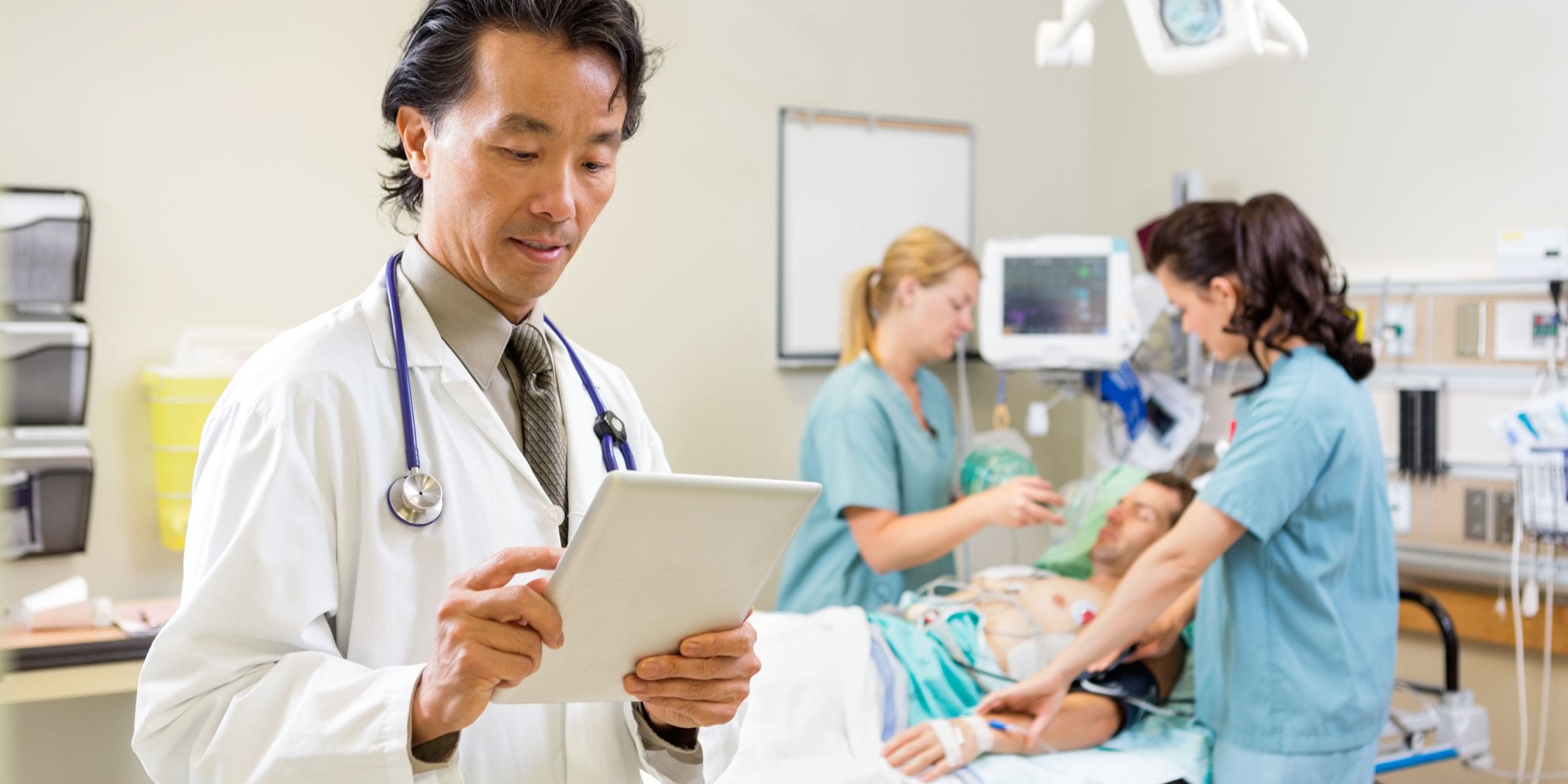 Male doctor on tablet in emergency room