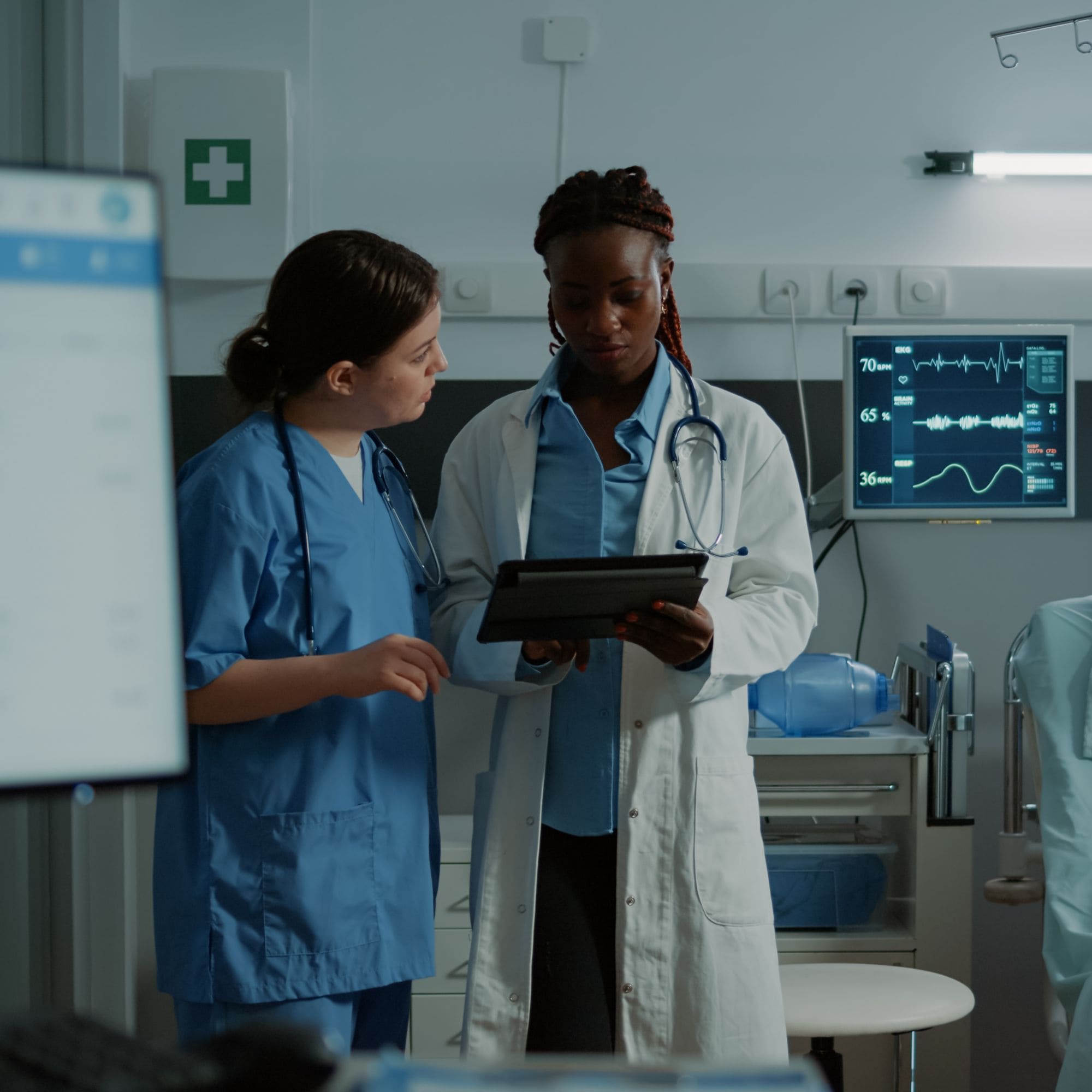 Female doctor and female nurse looking at tablet in emergency room